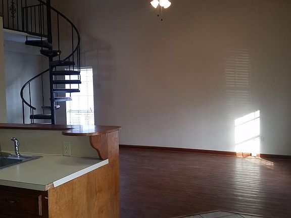 Open kitchen and living area with spiral staircase to loft