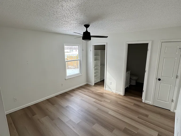 Spacious primary bedroom with natural light and updated flooring.