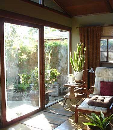 Floor to ceiling windows look out to landsaped patio and back yard.