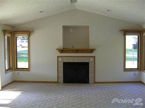 Large family room features a gas fireplace , vaulted ceiling, light and airy, and even a recess above the fireplace for a TV.