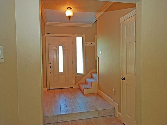 Powder Room door is on the right. It's nicely updated. Notice crown molding and beautiful tile flooring.