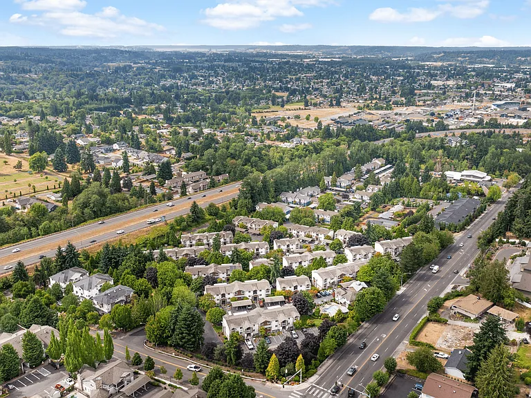 Bird's-eye view of the community with lush greenery and convenient access to major roads.
