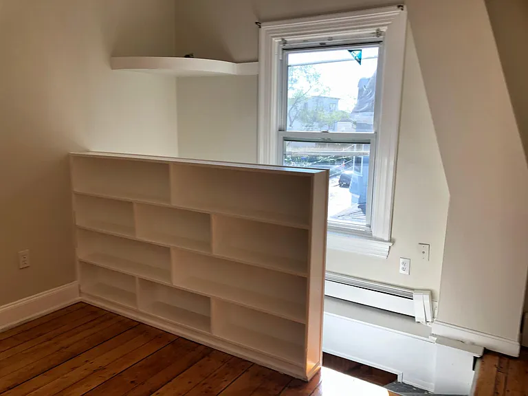 Behind bookcase is window and stairs to your front entrance.