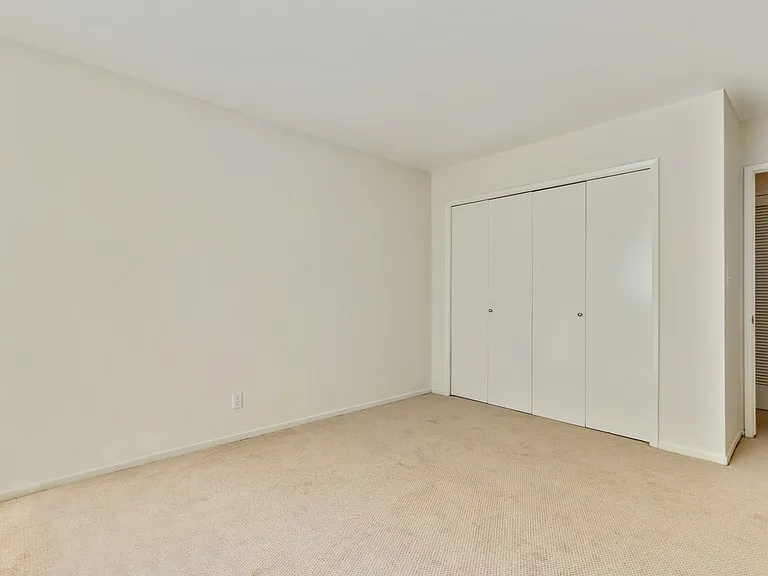 Bedroom with sliding closet doors, carpet flooring