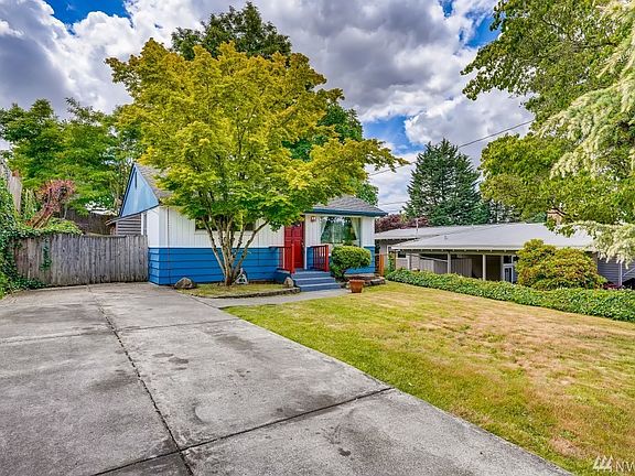 Front exterior of home with ample off street lined with beautiful trees and peak boo views of Lake Washington!
