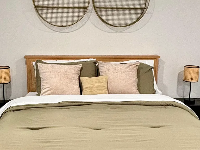 Comfortable bedroom featuring a dressed bed, coordinating decor, and bedside lamps for convenient nighttime lighting.