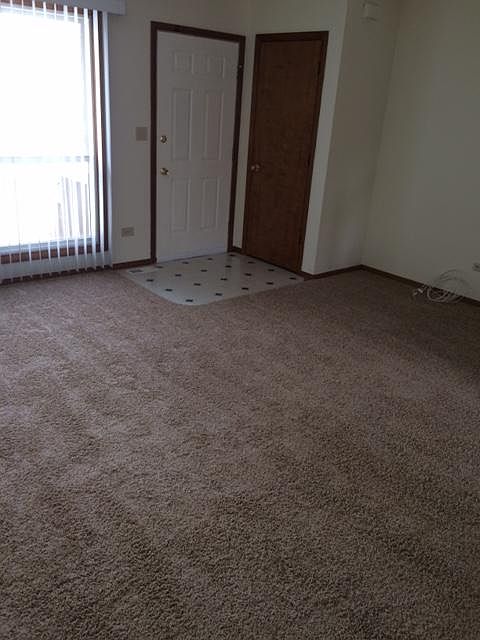 Living room at front door with a coat closet.