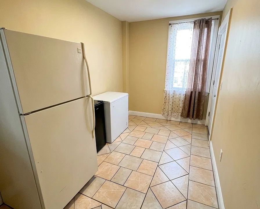 Pantry / kitchen extension. Additional pantry and utility area located just off the kitchen, providing extra storage and functional space. Refrigerator shown is being replaced as part of the planned appliance upgrades prior to move-in.