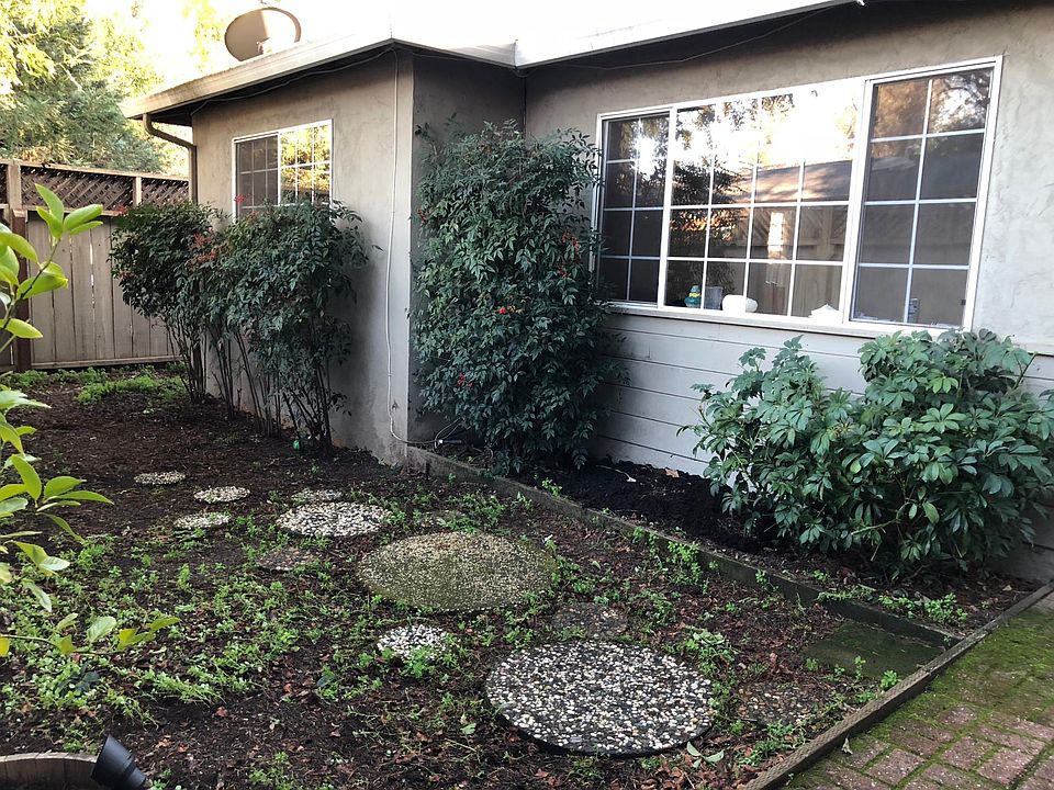 Left of front glass door showing large living room window an
