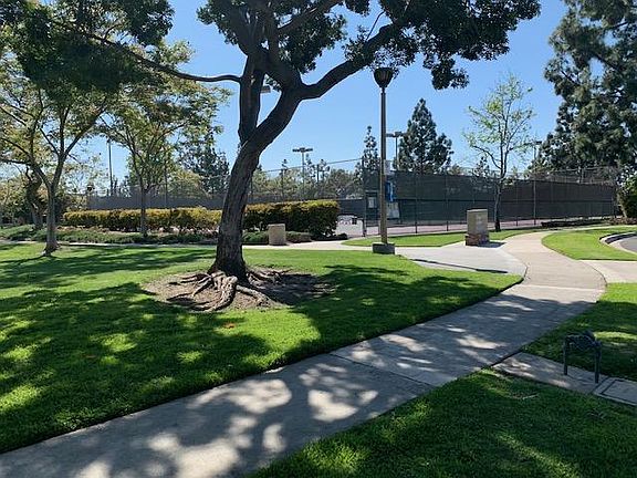 View of park directly outside of front door with childrens' playground and tennis courts within walking distance.