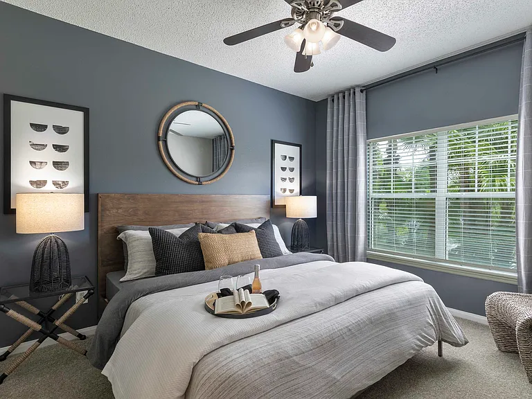 Primary bedroom with large window and ceiling fan