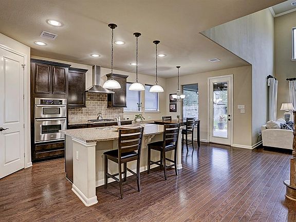 The wood floors continue through the fabulous kitchen and family room! Stainless steel appliances with built in oven, convection microwave, gas cook top and vent hood! Large island with pendant lights!
