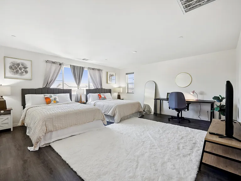 Enjoy two queen-size beds and a functional workspace in this inviting room.