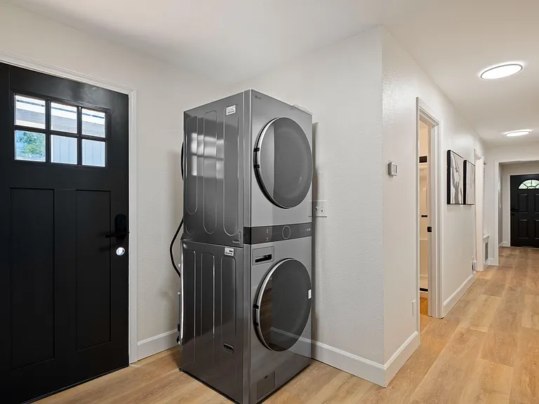 Convenient in-home laundry area with stacked washer and dryer, located off the entry hall for easy everyday use.