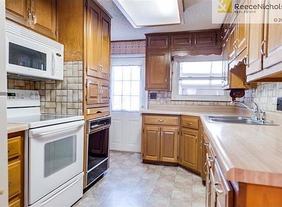 Kitchen features butcher block counter tops with tile backsplash.