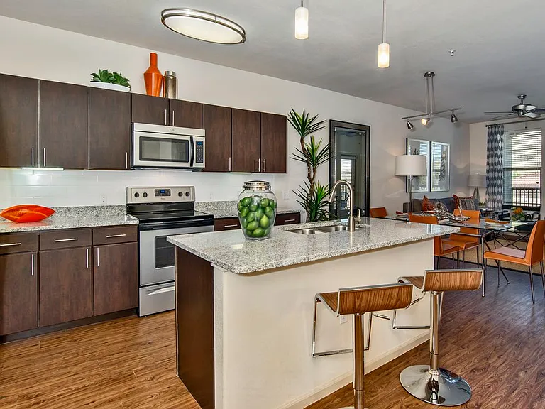 Classic Package I kitchen with espresso cabinetry, speckled granite countertops, white subway tile backsplash, stainless steel appliances, and hard surface flooring