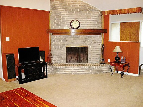Cozy brick corner fireplace provides a warm ambiance for this home. Also large TV wall, so bring you