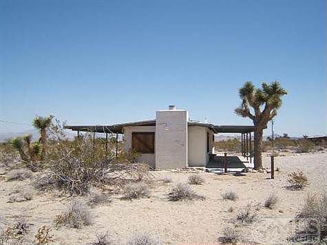 South end of house, shows both covered patios.  Security light on fireplace chimney.