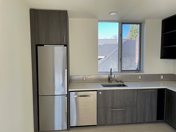 L shaped kitchen with ample counter space and stainless steel appliances