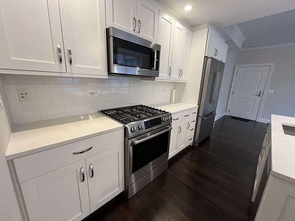Kitchen with modern appliances (gas range, microwave, refrigerator/freezer, dishwasher) and quartz countertops