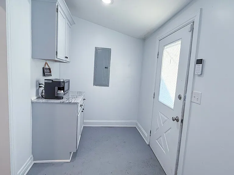 Large mudroom with washer/dryer, coffee/microwave area, and feeding space for pets