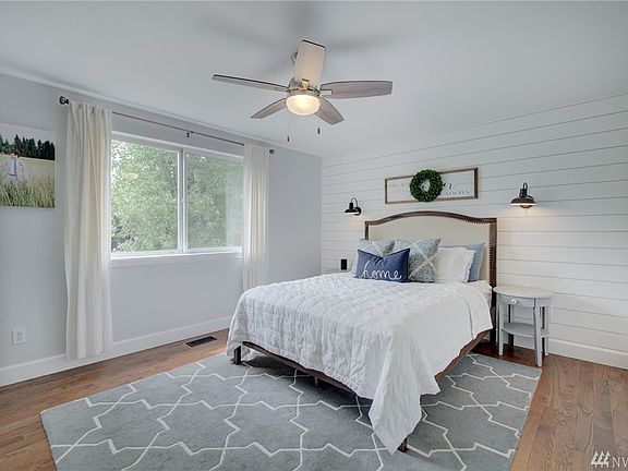 Gorgeous wood floors and a feature wall of shiplap with custom lighting make this home look like it's right out of an HGTV show!