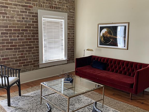 Large, open living room offer plenty of natural light from the 2 windows with sofa and 2 chairs