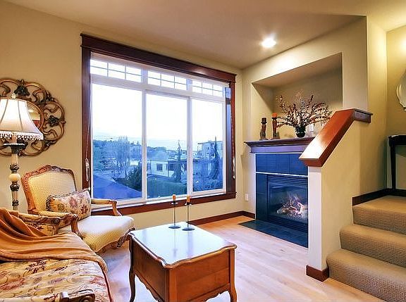 The Lovely Living Room Has A Fireplace, Hardwood Floors And Windows Galore