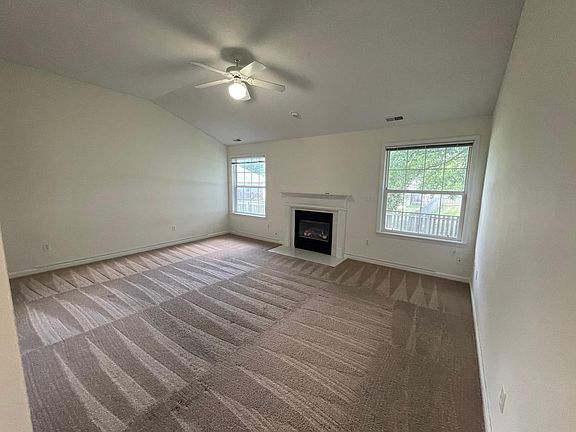 Living room with gas fireplace overlooking fenced in back yard
