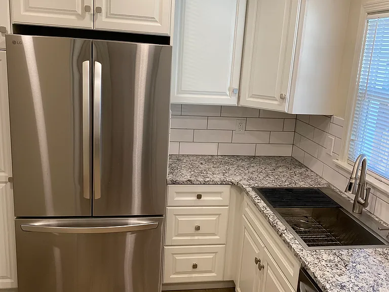 New kitchen remodel with granite countertop and stainless steel appliances.