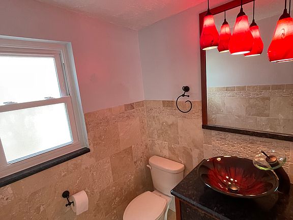 Half bathroom off the kitchen with a door leading to the pool.