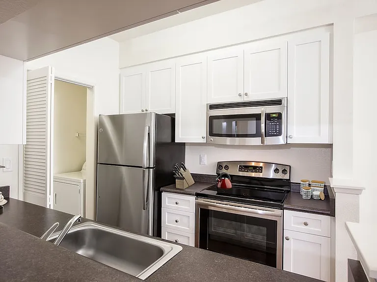 Classic Package I kitchen with stainless steel appliances, white cabinetry, laminate countertops, and hard surface flooring