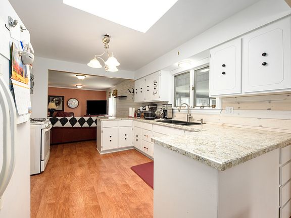 Large eat-in kitchen with skylight and walk in pantry with pull-out drawers.
