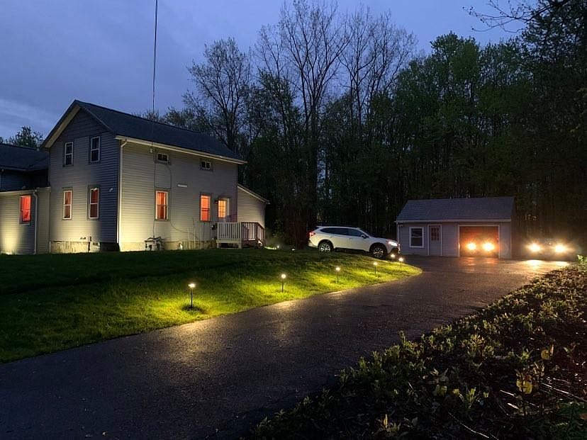 Front of the Home and Driveway with 3 cars parked without blocking each-other. Cars: - BMW X5 in garage, Honda Accord next to garage, and Subaru Outback truck.