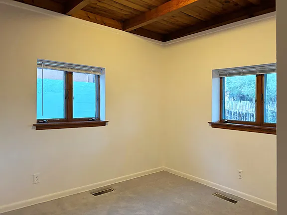 Smaller bedroom is carpeted