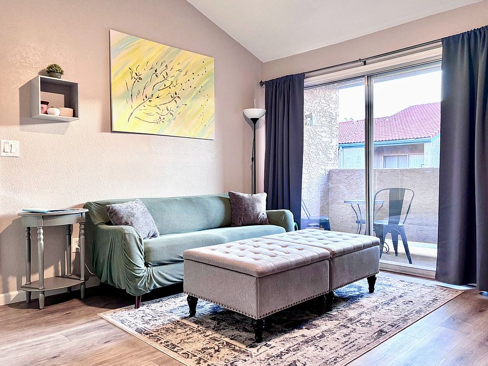 living area with two storage ottomans and entrance to private balcony