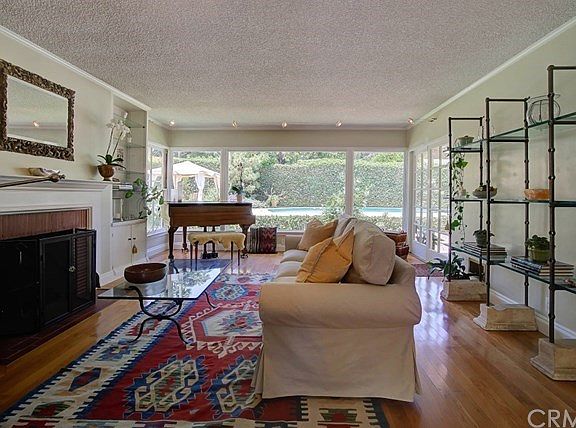 Warm and inviting living room with hardwood floors, fireplace and wall of windows bringing in much natural light while connectin