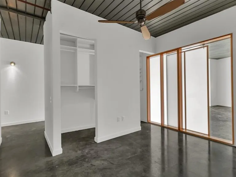 Spacious bedroom with sliding doors to kitchen and generous closet