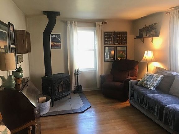 Wood burning stove sets the style in the formal living room with wood floors and large picture room