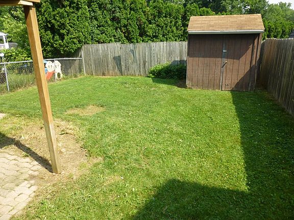 small fenced backyard with shed