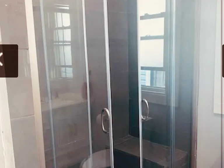 large walk-in shower with a seat in the shower and a 60 inch double vanity.