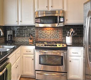 Custom back splash with glass tiles for a WOW centerpiece for this kitchen