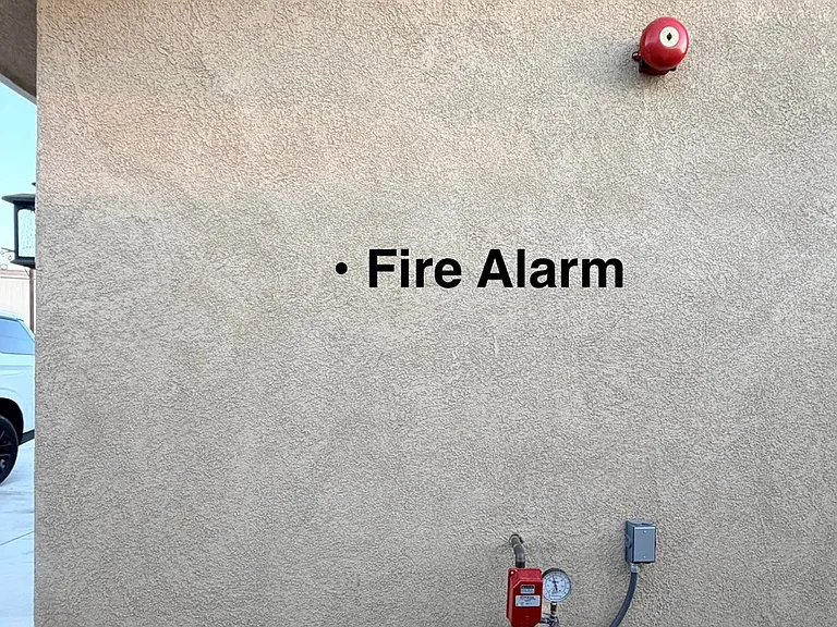 FIRE ALARM mounted outside garage wall for fire sprinklers placed throughout home