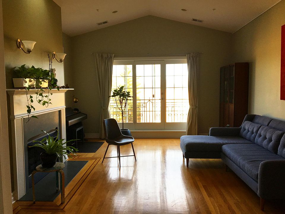 Large and bright living room has a skylight, balcony, and gas fireplace. Full views from all windows.
