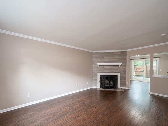 Living Room Fireplace with tile surround. View into Dining Room and the outdoor gated patio