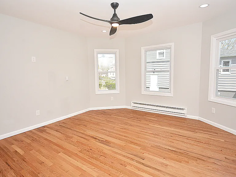 Living room - beautiful new hardwood floors, bay windows, can lights, and lighted ceiling fan. Outlet on wall perfect for wall mounted TV.