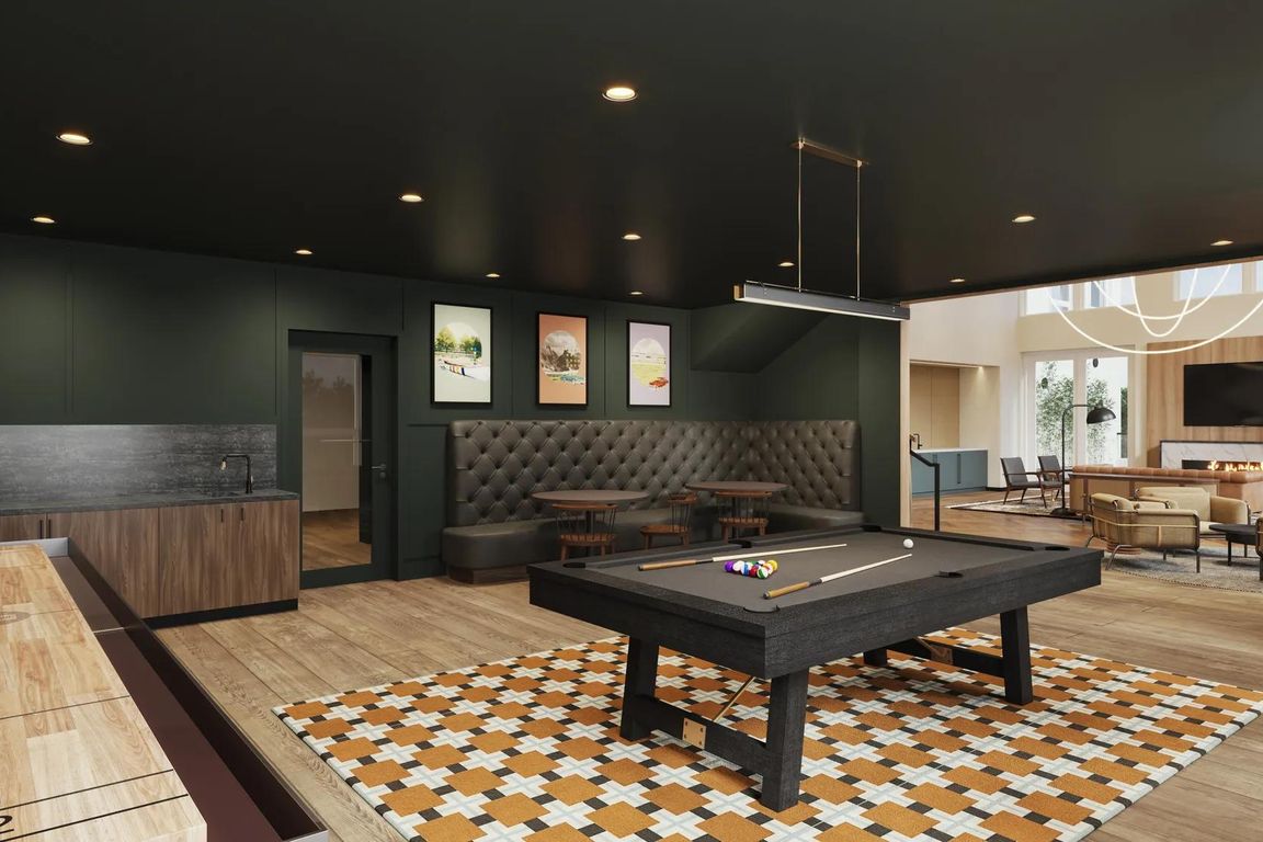 Game room with billiards, shuffleboard, and game tables at Modera Shoreline apartments in Shoreline, WA.