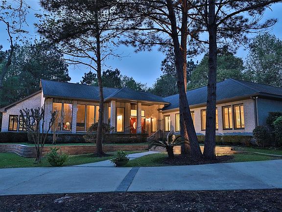 CLASSIC ONE-STORY HOME WITH VERSATILE FLOOR PLAN - Photographed at dusk, this stunning home is a class all in itself. The floor to ceiling windows surround the living areas of the home giving the homeowner a complete view of the grounds, which set a 