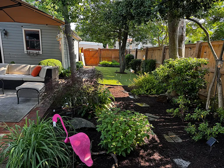 Backyard, artificial turf and garden plot on back fence.