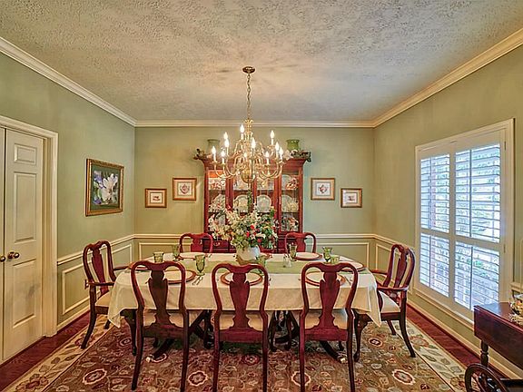 Formal dining has crown molding, chair rail and plantation shutters.